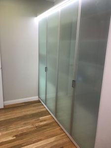 Polytec-Frosted-Glass-Doors-in-Front-of-Chrome-Hanging-Rods-Shelving