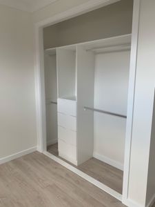 Built-In-Wardrobe-with-a-Bank-of-Shelves-and-Chrome-Hanging-Rods